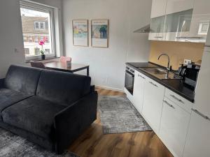 a living room with a couch and a kitchen at Zeitperlewohnen Petrol in Witten +8 photos