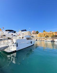 un bateau blanc est amarré à un quai dans l'eau dans l'établissement Barco muy acogedor en Valencia, à Puebla de Farnals