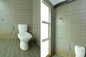 a bathroom with a toilet and a window at Hotel O Sohotel in Klang