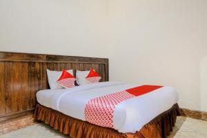a bedroom with a large bed with red and white pillows at Hotel O otel Graha Prima in Tamperan +39 photos