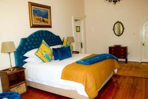 a bedroom with a large bed with a blue headboard at Carmichael House Boutique Hotel in Cape Town +126 photos