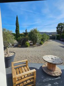 a patio with a table and a bench and a table at La toulousaine in Sablons