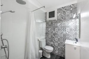 a white bathroom with a toilet and a shower at Acogedor apartamento en Betlem in Colonia de Sant Pere +20 photos