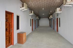 an empty hallway with white walls and a red door at Hotel O Pancing Near Universitas Negeri Medan UNIMED Formerly Nadira Homestay in Medan