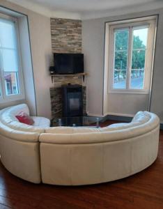 a large white couch in a living room with a fireplace at Gite Compostella in Saint-Jean-Pied-de-Port