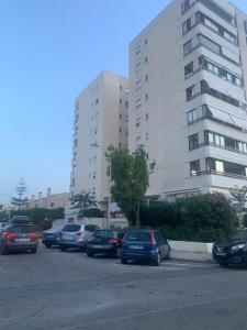 a parking lot with cars parked in front of a building at Global Sun - Casa Pasco in Playa de Gandia