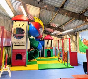 a childrens play room with a slide and play equipment at Wallows Lodge with private hot tub in St Austell