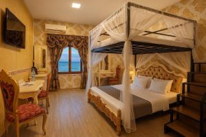 a bedroom with a canopy bed with a view of the ocean at Jessica Flat Malta Royal Guesthouse in Cospicua