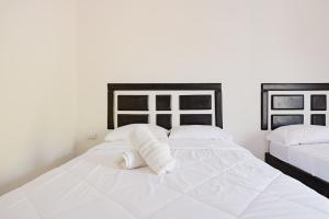 a bedroom with two beds with white sheets and towels at Casa Chika Playa Grande Guanacaste 3 in Cuajiniquil