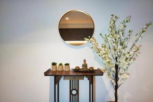 阿德莱德Luxury City Zen Apartment Rundle Mall with Gym, BBQ的梳妆台,配有镜子和一棵树