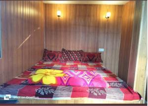 a bedroom with a large bed with a colorful blanket at Swastik Guest House in Arambol