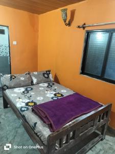 a bed in the corner of a room with a window at Swastik Guest House in Arambol