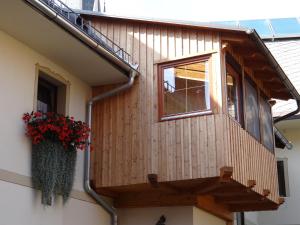 a balcony on a house with a window and flowers at Schlummerburg in Weißkirchen in Steiermark