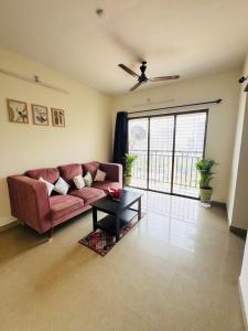 a living room with a pink couch and a table at Home Sweet Home in Thane