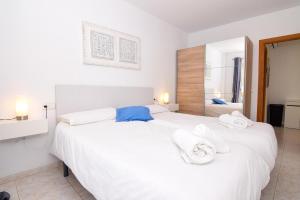 a bedroom with two white beds with towels on them at Precioso apartamento cerca de la playa in Colonia de Sant Pere