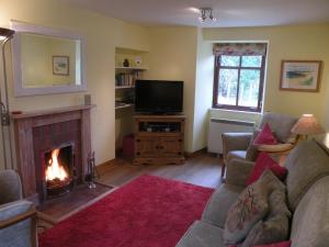 a living room with a fireplace and a television at McHugh and Loudon Cottages in Saint Catherines