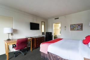 a hotel room with a bed and a desk and a computer at OYO Hotel Sumter SC Downtown in Sumter +21 photos