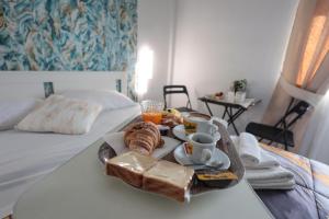 a breakfast tray with bread and coffee on a bed at A cartulina e Napulè Attico con Vista Porto Ascensore Colazione Inclusa Struttura nel cuore autentico di Napoli a 5 minuti dalla Stazione Centrale e dal Centro Storico AC in Naples