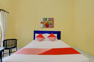 a bedroom with a bed with red and blue at OYO 3096 Hotel Dewi Warsiki Near Gilimanuk Port in Gilimanuk