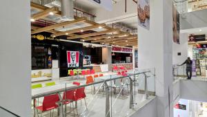 a store with a counter with red chairs in it at Lyallpur Galleria Mall Apartment, 1 BHK, 1 Bedroom with Living Room, Basement Parking, 24x7 Security in Faisalabad