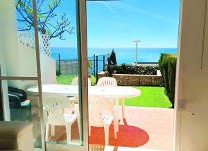 a table and chairs on a patio with a view of the ocean at Ara Bela Duplex con jardin in Peniscola