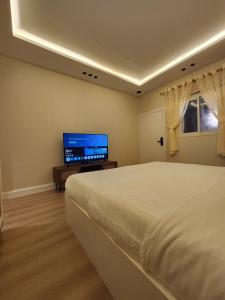 a bedroom with a bed and a flat screen tv at ComfyStay KSA - Boho-Chic Studio Near Cafés in Riyadh