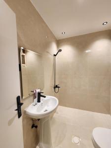 a white bathroom with a sink and a shower at ComfyStay KSA - Boho-Chic Studio Near Cafés in Riyadh +6 photos
