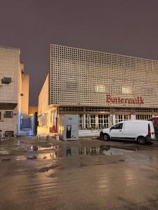 a white van parked in a parking lot in front of a building at ComfyStay KSA - Boho-Chic Studio Near Cafés in Riyadh