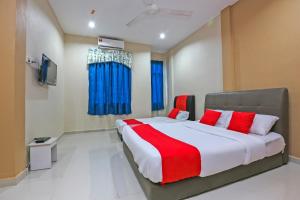 a bedroom with a large bed with red and white pillows at OYO 89933 Nun Hotel in Jeli