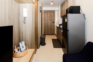 a small kitchen with a refrigerator in a room at Charlie's Staycation at Coast Residences in Manila