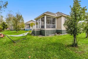 een huis met een hangmat voor een tuin bij Le Papillon - 77 Butternut in Cherry Valley