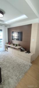 a living room with a flat screen tv on a wall at Apartamento coração meia praia in Itapema