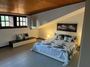 Un dormitorio con una cama grande y dos ventanas. en Vacanze in Mansarda, en Oristano