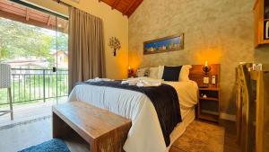 a bedroom with a bed and a large window at Villa Tirol - Monte Verde in Monte Verde