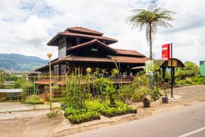 a building with a garden in front of it at Capital O 2640 Cottage GS Rumah Kayu Syariah in Batureo 1