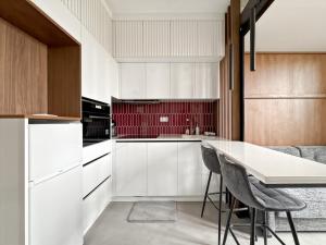 a kitchen with white cabinets and a table and chairs at La White box in Trévoux +18 photos