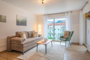 a living room with a couch and a table and a window at Ferienwohnung Predigtstuhlblick Bad Reichenhall in Bad Reichenhall