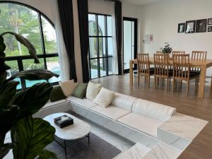 a living room with a white couch and a table at V Villa Khaoyai in Ban Nong Ka Cha