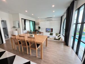 a dining room and living room with a table and chairs at V Villa Khaoyai in Ban Nong Ka Cha