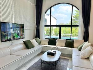 a living room with a white couch and a table at V Villa Khaoyai in Ban Nong Ka Cha