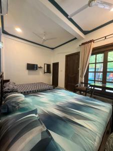 a room with three beds and a window at Hotel UK Pasikuda in Kalkudah