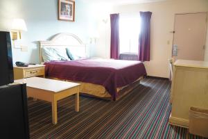 a hotel room with a bed and a window at Richmond - Quality Quarters Inn in Richmond +29 photos