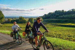 a group of people riding bikes down a road at paysmillereves in Fumel