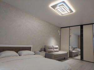 a bedroom with a bed and a chair in it at DreamTown Однокімнатна біля вокзалу in Luts'k