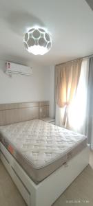 a white bed in a room with a window at Apartamento coração meia praia in Itapema