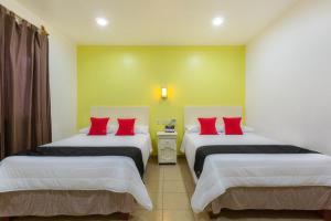 Postel nebo postele na pokoji v ubytování Capital O Oaxaca Guest Hotel