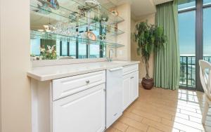 オレンジビーチにあるPhoenix West 1209 condoの白いキッチン(シンク、鏡付)