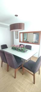 a dining room table and chairs with flowers on it at Apartamento coração meia praia in Itapema +11 photos