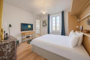 a bedroom with a large white bed and a desk at Villa Victor Hugo by Odomo in Avignon