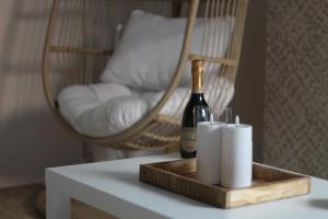 a bottle of champagne and two rolls of toilet paper on a table at Suite Banjar-Luxe,Balnéo & Sauna in Saint-Aubin-dʼAubigné